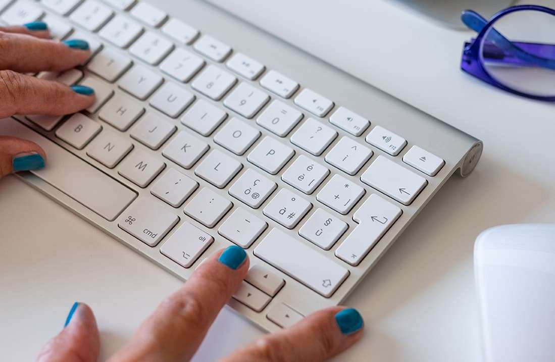 Working at home with computer, woman writing a blog. Female hand